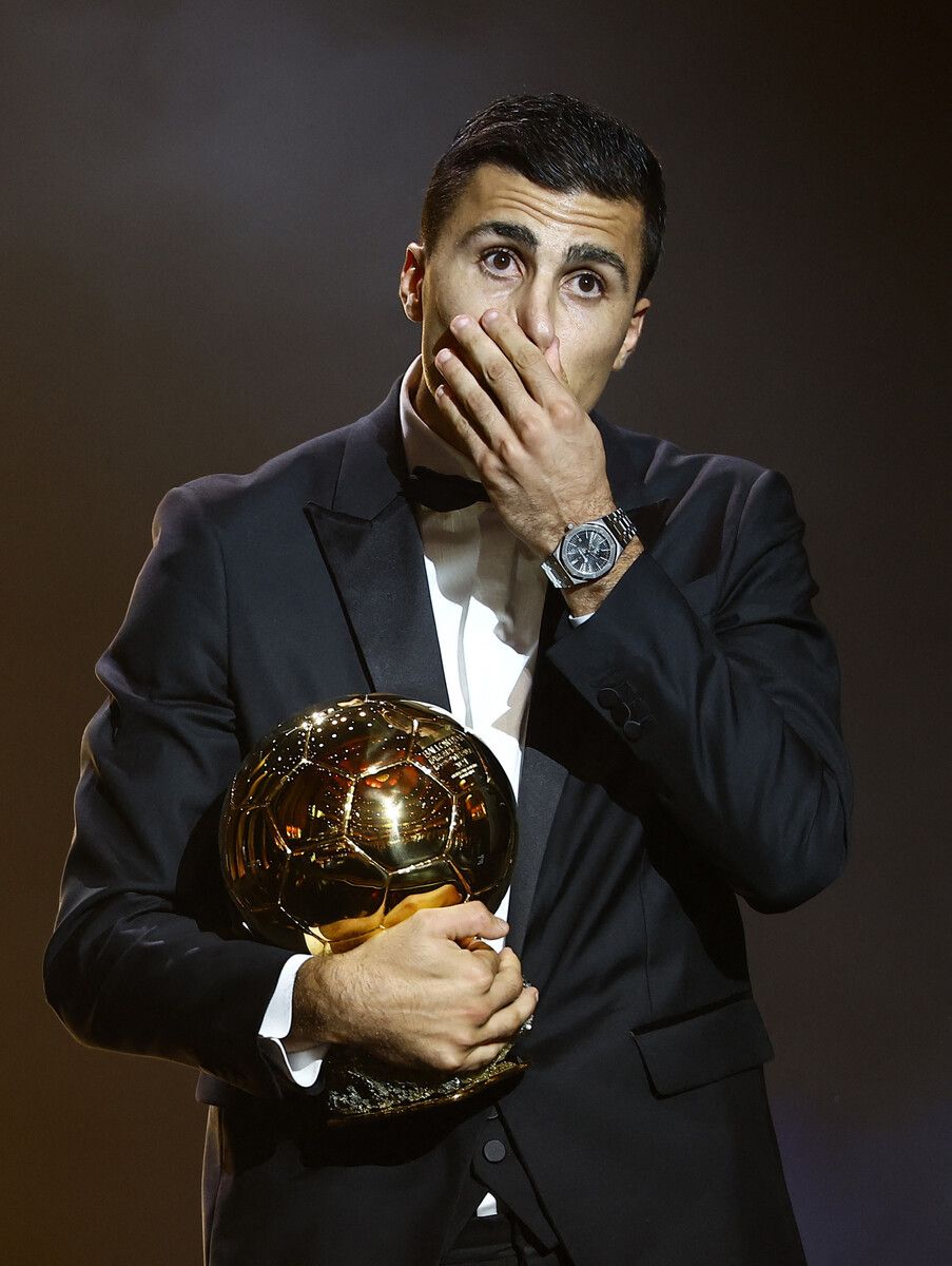 Ein glücklicher Rodri hält den goldenen Fußball fest in seinen Händen.⇒ap