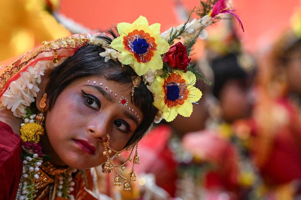 Ein junges Mädchen, gekleidet als Hindu-Göttin „Durga“, sitzt während eines Festivals in Kalkutta in der Nähe des Idols der Gottheit. AFP