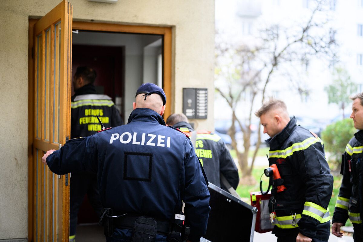Einsatzleute von Polizei und Feuerwehr gestern auf dem Weg zum Tatort.⇒apa