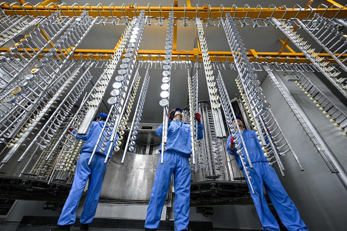 So werden Flaschenverschlüsse hergestellt: Mitarbeiter arbeiten am Fließband in einer Fabrik in Suqian, Ostchina. AFP