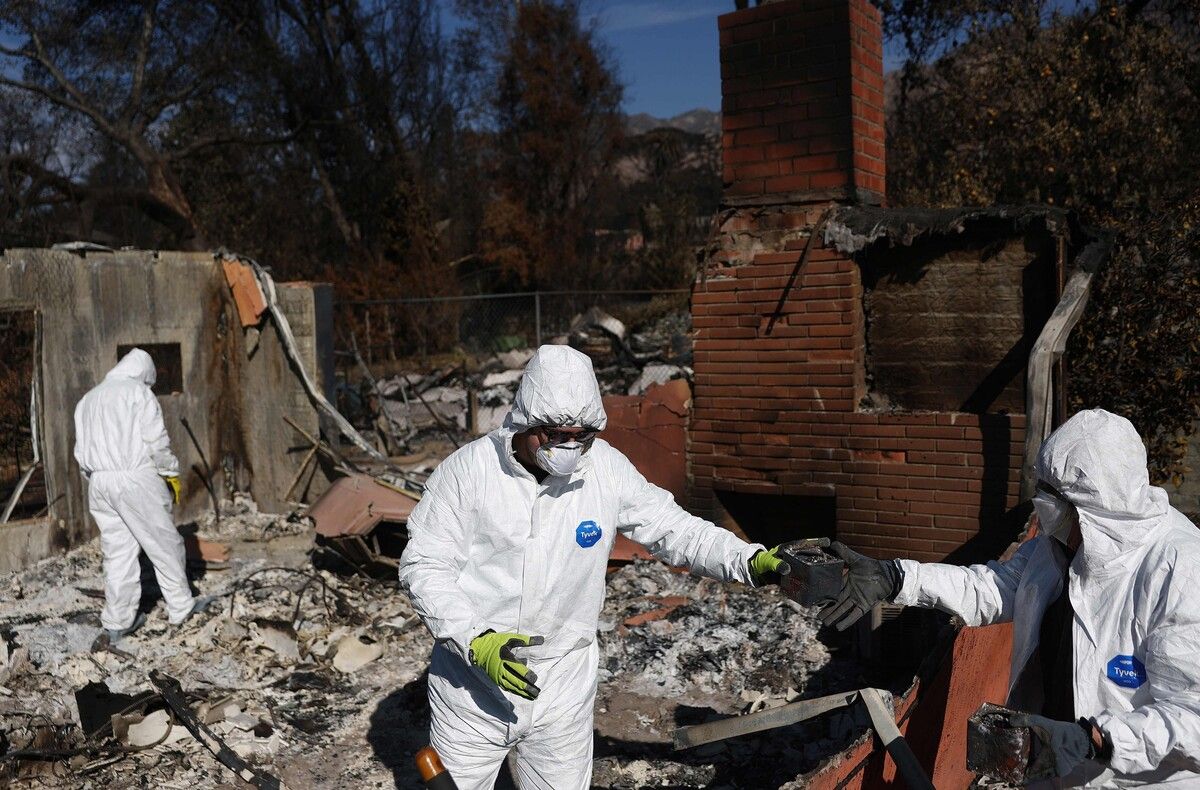 Anwohner müssen bei den Aufräumarbeiten Schutzkleidung tragen.⇒afp