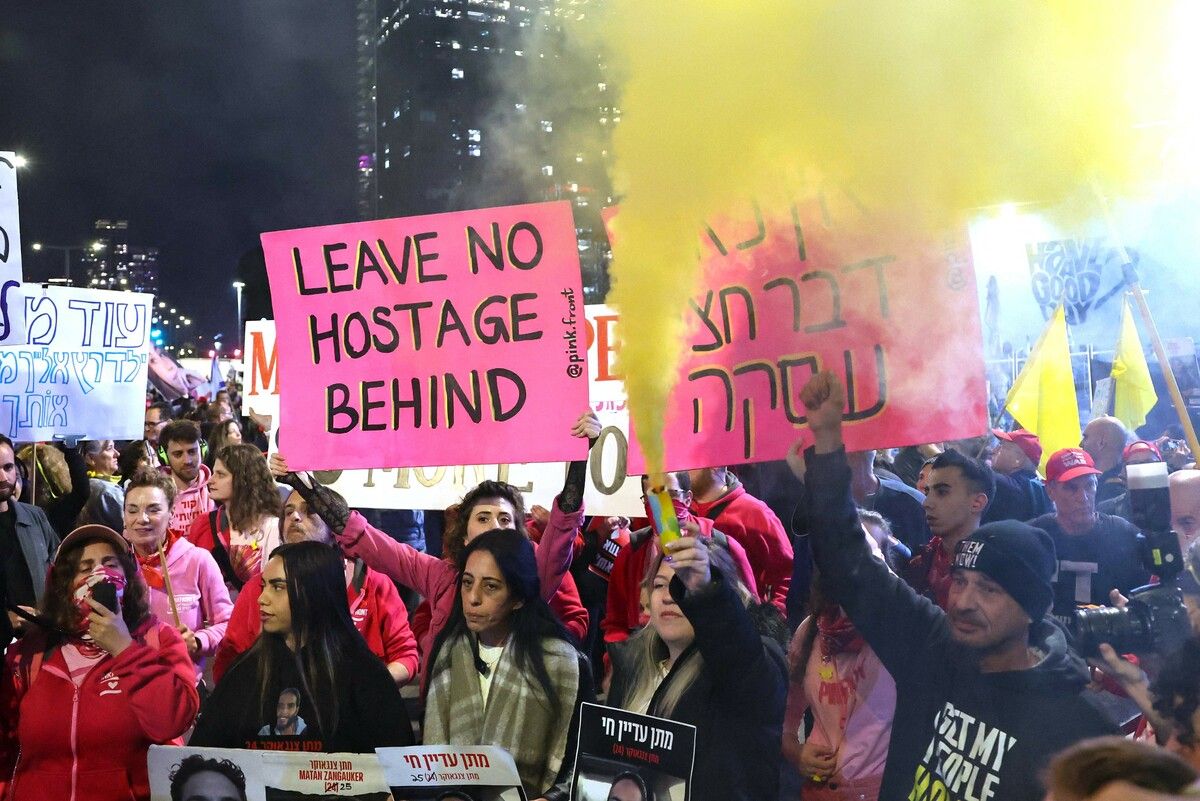Demonstranten halten in Tel Aviv Plakate hoch und stoßen Rauch aus, während sie die Freilassung der in Gaza gefangenen Geiseln fordern. AFP