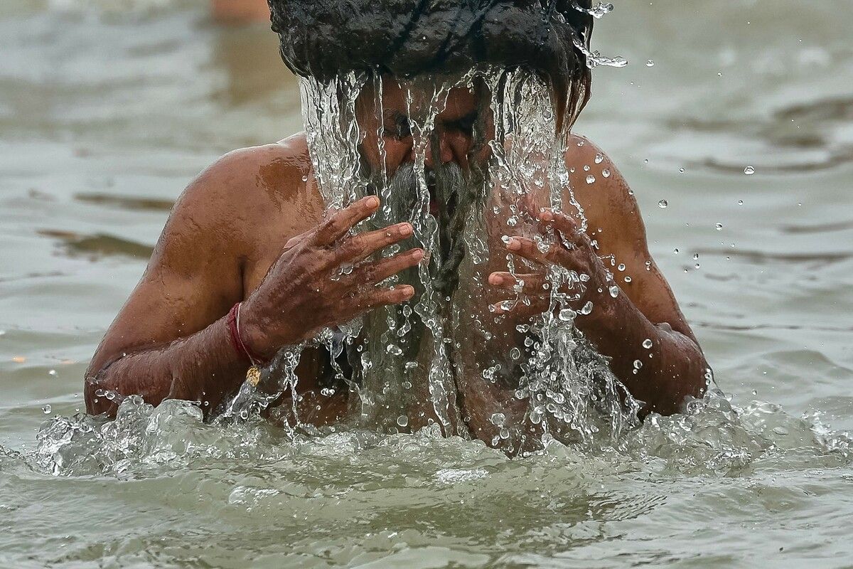 Ein Mann taucht während Kumbh Mela - dem größten religiösen Fest des Hinduismus - in Prayagraj in die heiligen Gewässer von Sangam. AFP