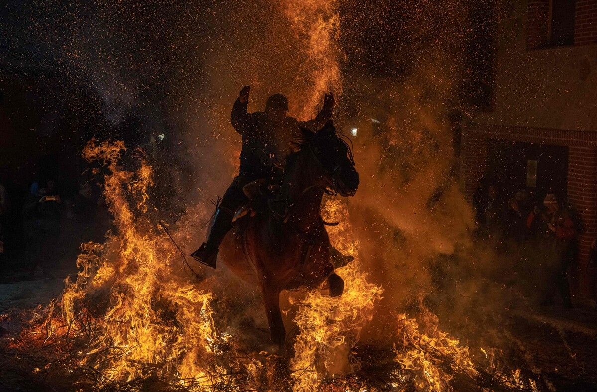 Ein spanischer Reiter galoppiert während des traditionellen Festes „Las Luminarias“ zu Ehren des heiligen Antonius durch ein Feuer. AFP