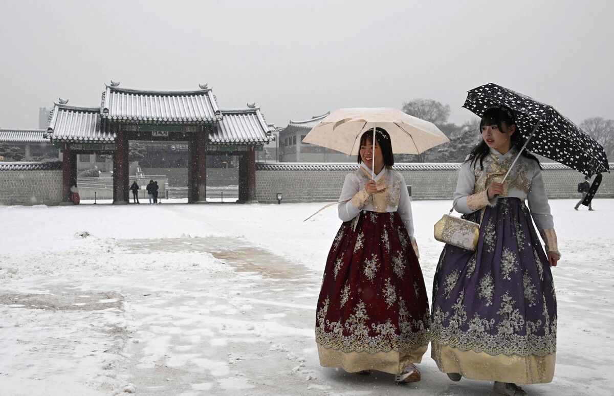 Die Besucherinnen lassen sich trotz Schneefalls nicht vom Besuch des Gyeongbokgung-Palastes im südkoreanischen Seoul abhalten. afp
