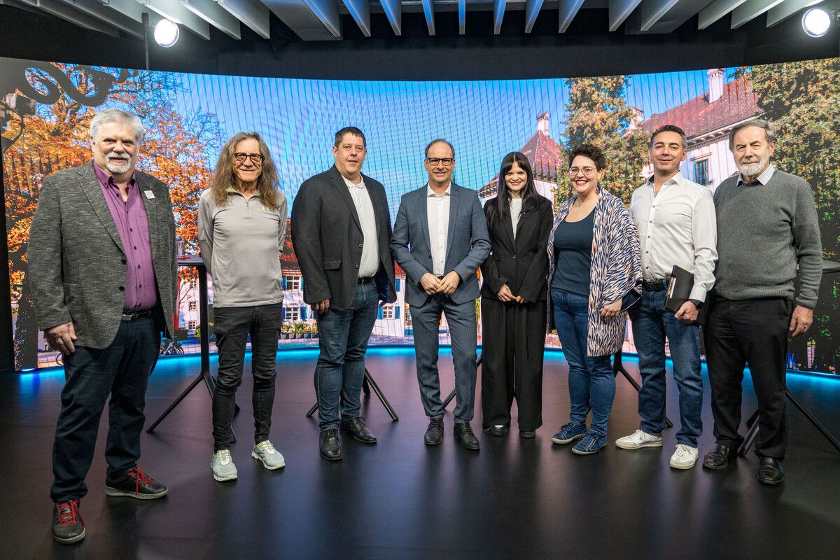 Die sieben Kandidaten für das Hohenemser Bürgermeisteramt: (v. l.:) Günter Zechner (SPÖ), Bernhard Amann („Ems isch üsr“), Thomas Fussenegger (ÖVP), Dieter Egger (FPÖ), Maria Benzer (Grüne), Christian Mathis (Neos) und Arnulf Häfele (Emser Liste) mit VN-Moderatorin Magdalena Raos. ⇒VN/Rhomberg