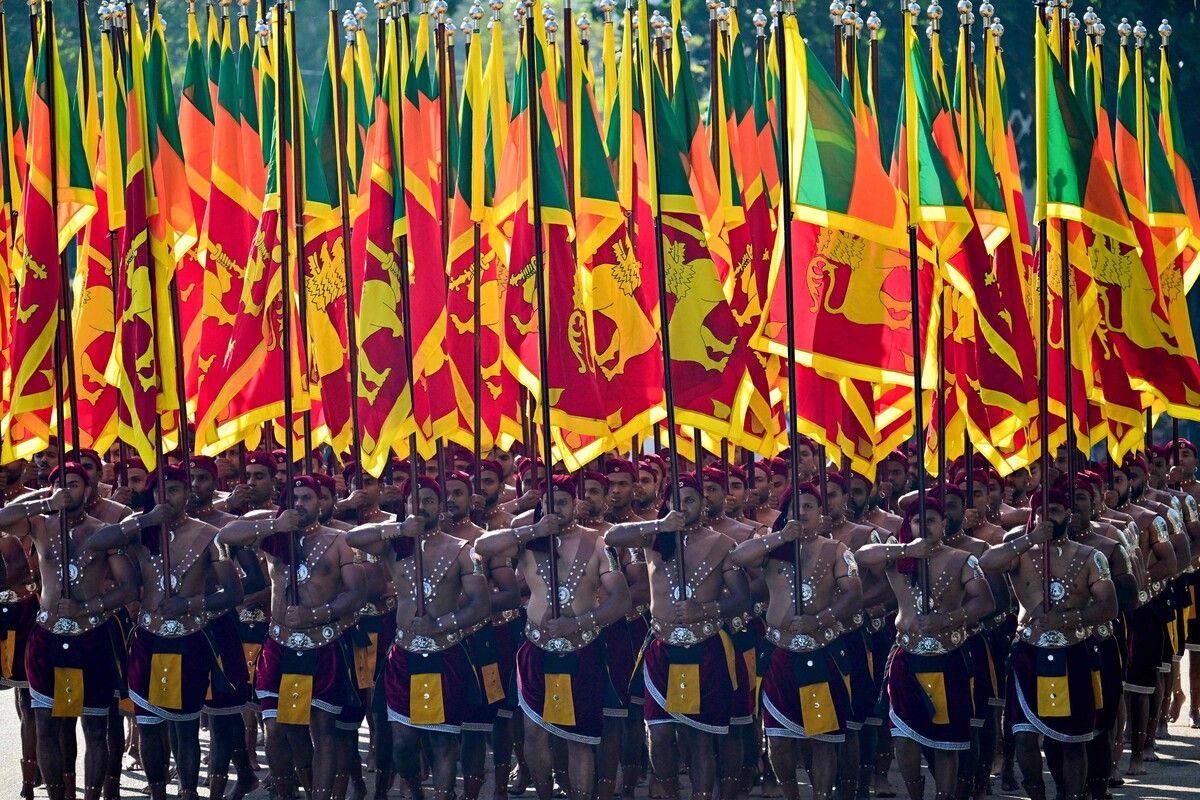 Eine Kulturtruppe der srilankischen Armee marschiert mit Nationalflaggen bei den Feierlichkeiten zum 77. Unabhängigkeitstag Sri Lankas. afp