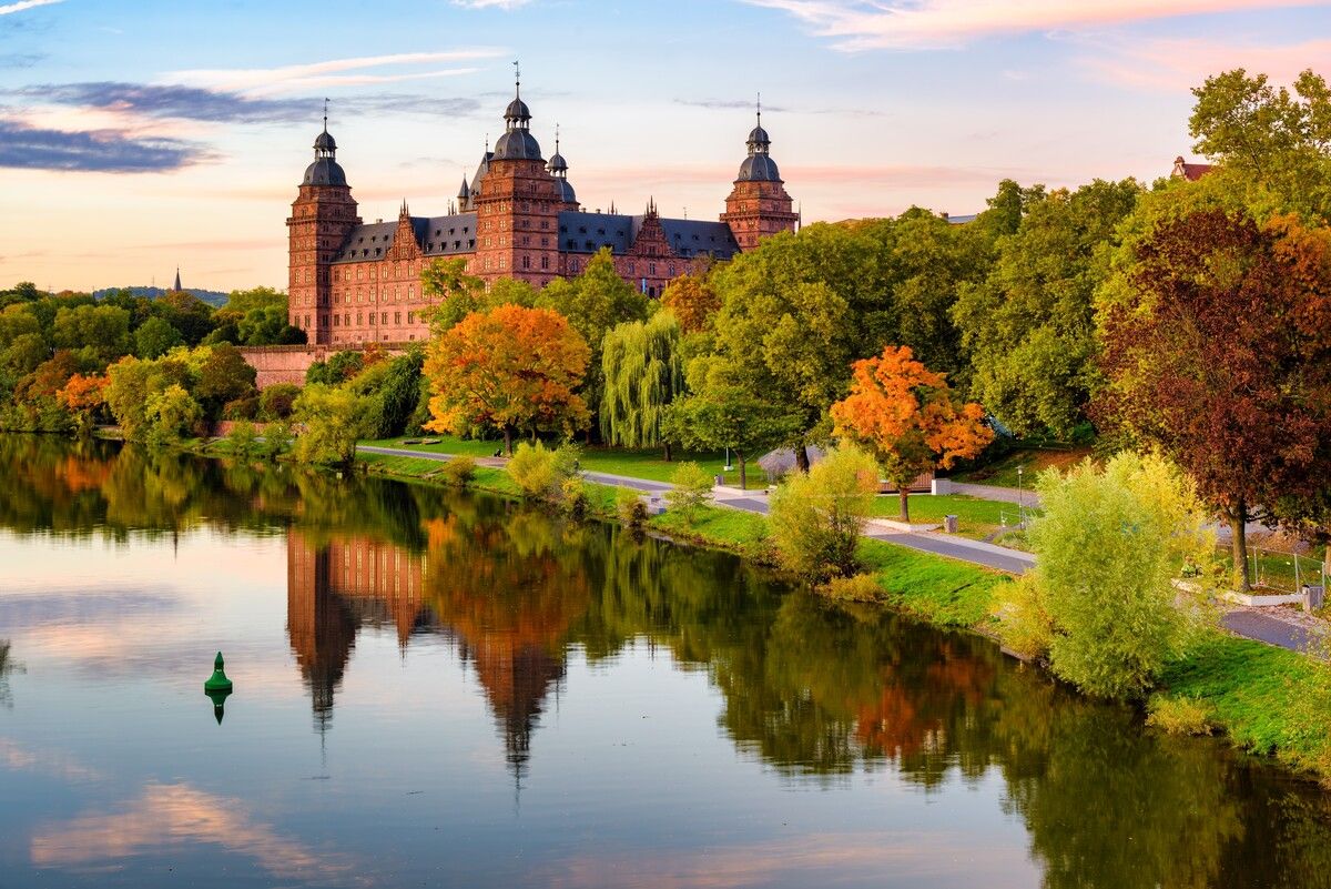 Das Schloss Johannisburg aus rotem Sandstein thront imposant über dem Main.⇒Shutterstock