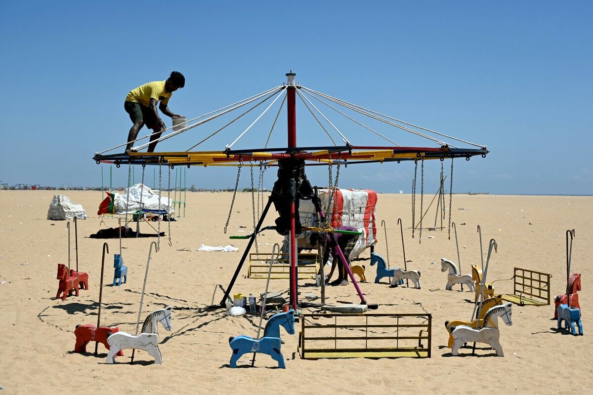 Dieser Mann streicht bei brütender Hitze ein Karussell am Marina Beach in Chennai in Indien. AFP