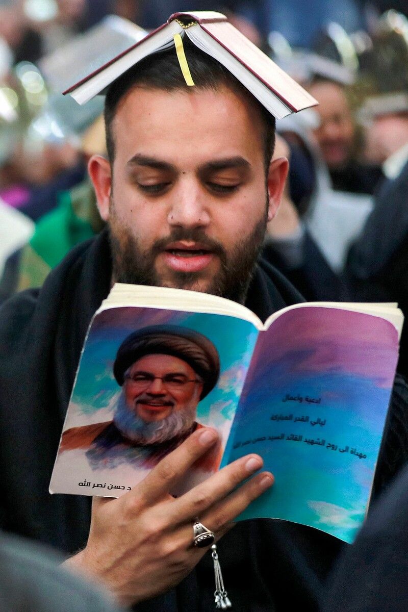 Ein Schiit betet im Irak mit dem Koran auf dem Kopf im Gedenken an Hassan Nasrallah, den getöteten Führer der libanesischen Schiitenbewegung Hisbollah. afp