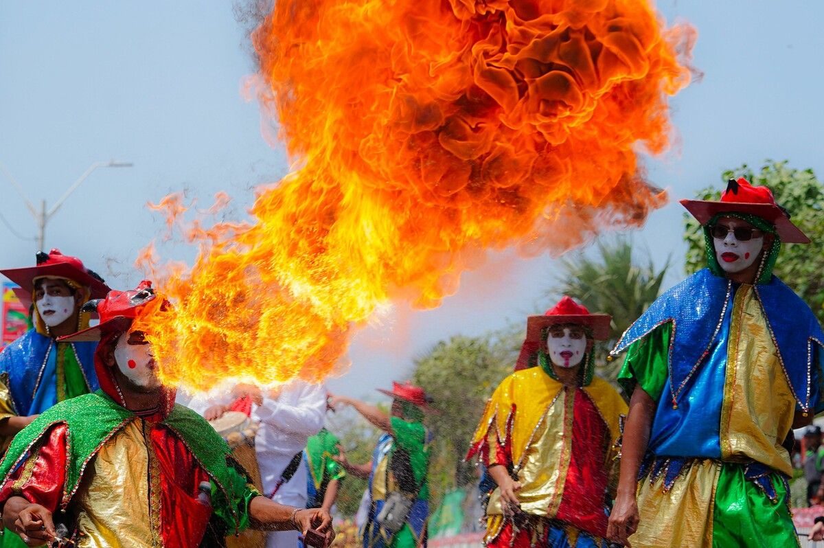 Feuerspuckend ziehen Teilnehmer des Karnevalsumzugs La Gran Cumbiamba in Barranquilla, Kolumbien durch die Straßen.