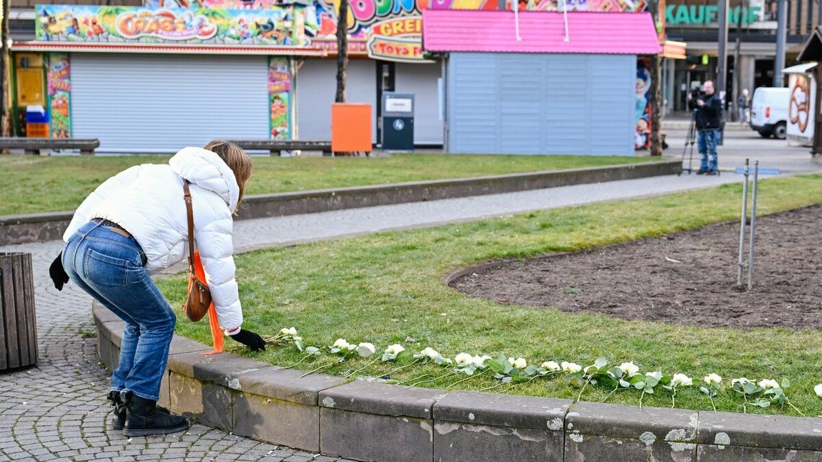 Menschen legen Blumen am zentralen Paradeplatz ab.⇒apa