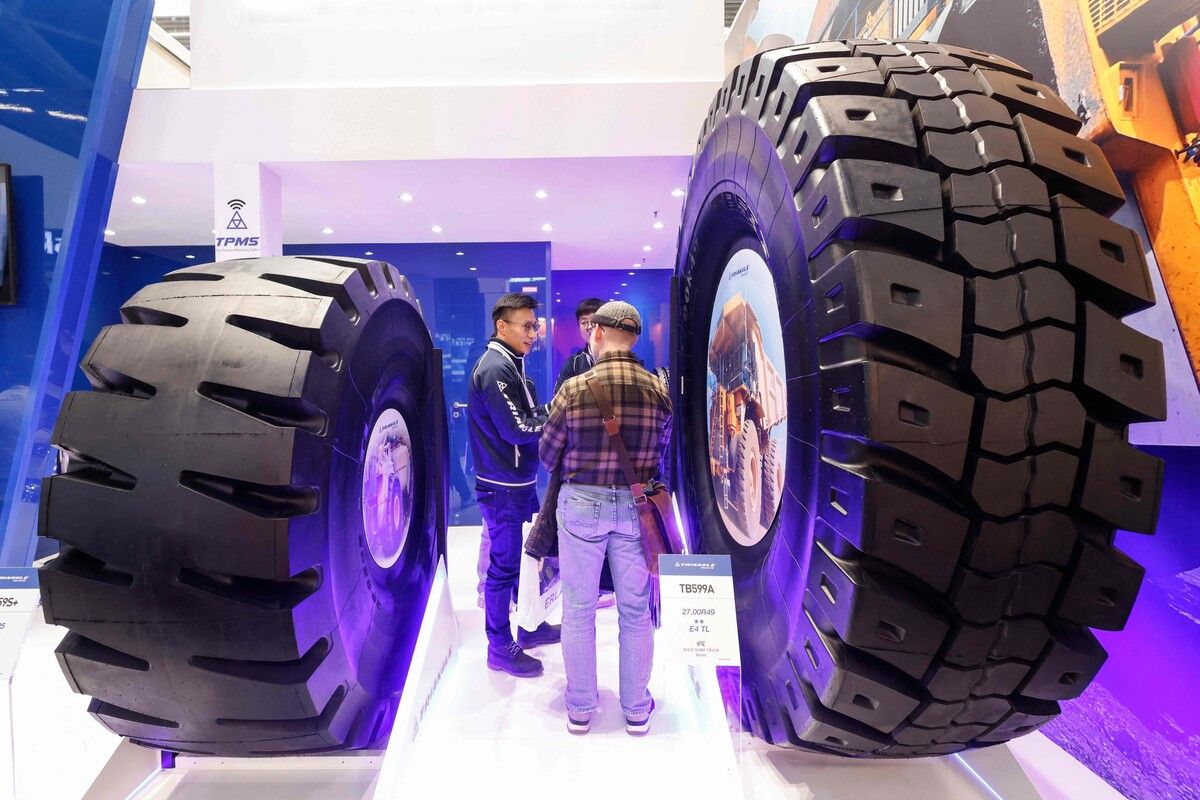 Besucher staunen nicht schlecht über die riesigen Reifen am Stand von Triangle auf dem Gelände der Bauma 2025 in München.