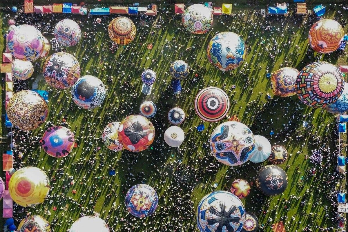 Heißluftballons, die zumeist aus Recyclingpapier hergestellt und mit Seilen zusammengebunden sind, schweben in Wonosobo, Zentraljava.