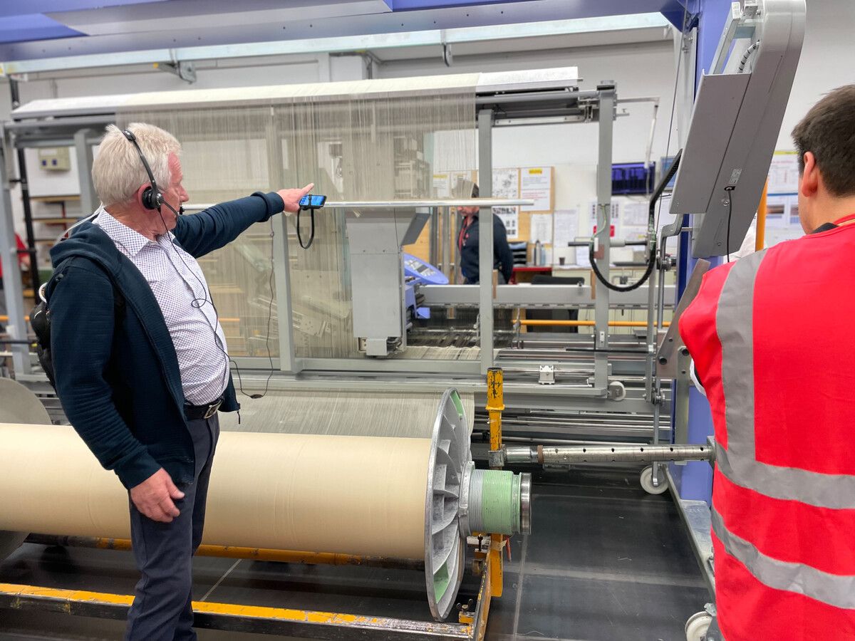 Klaus Suitner zeigt auf die einzelnen Fäden, die letzten Endes zu einem Gewebe zusammengewebt werden.⇒Getzner Textil(2)