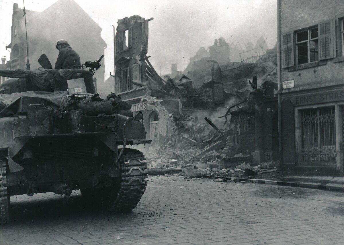Panzer fahren durch die zerstörte Rathausstraße in Bregenz. ⇒ECPA/Stadtarchiv Bregenz