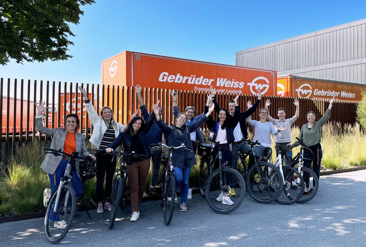 Radsport-Fans vor dem Gebrüder Weiss Head Office in Lauterach. Sie hoffen auf zahlreiche weitere Teilnehmer.⇒Fa