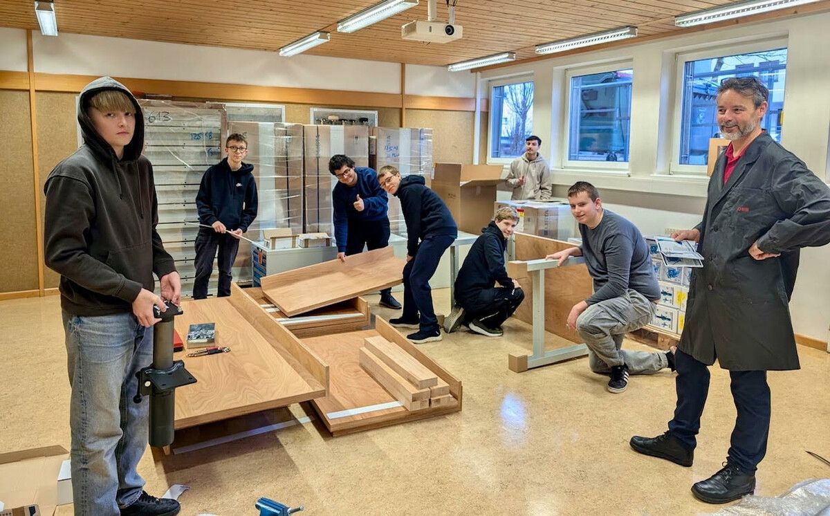 Schüler des Poly Bludenz und Elektrotechnik-Fachlehrer Dietmar Maier beim Aufbau der neuen Werkbänke.