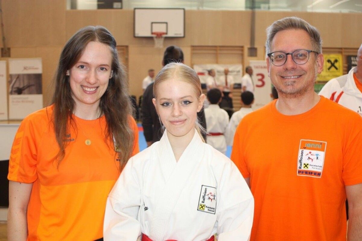 Lara Schnetzer (Mitte) freute sich mit Vater Michael Schnetzer und Obfrau Sarah Köchle über die erste Goldmedaille. ⇒vn/TK