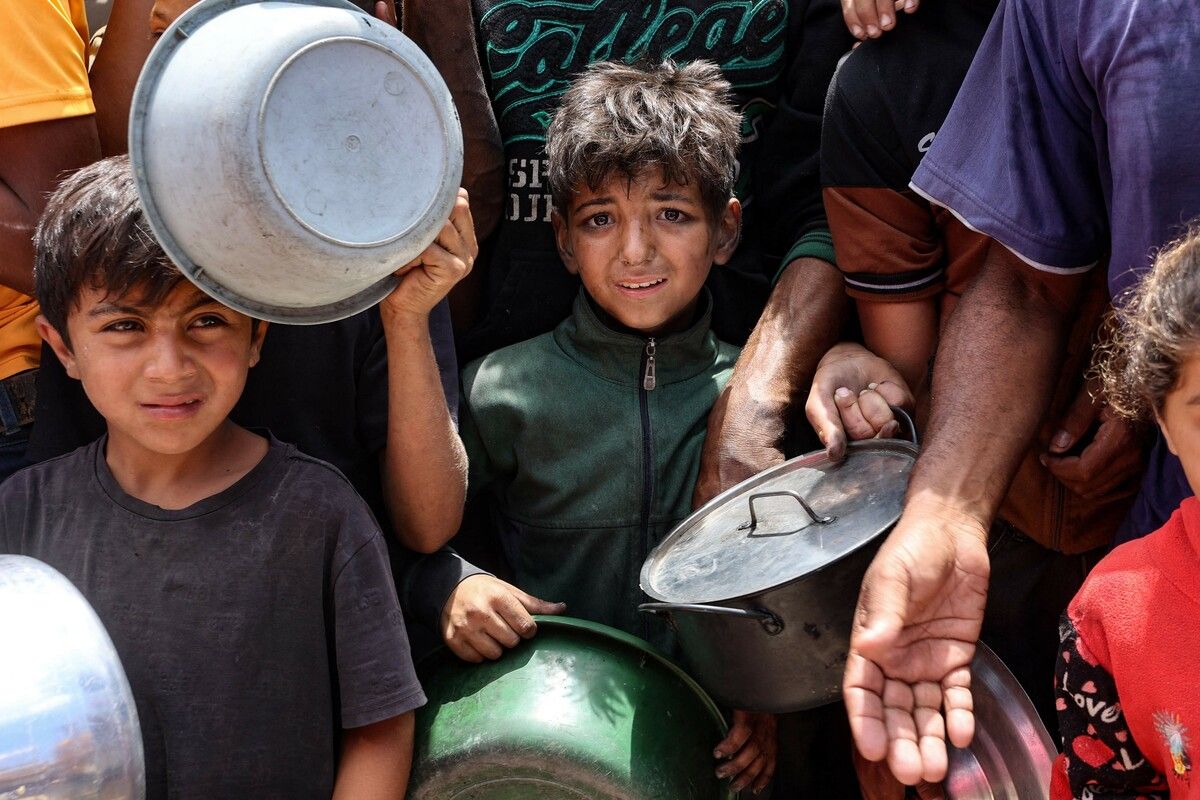 Palästinensische Kinder warten in einem Vertriebenenlager in der Nähe des Hafens von Gaza-Stadt auf Essen.⇒afp