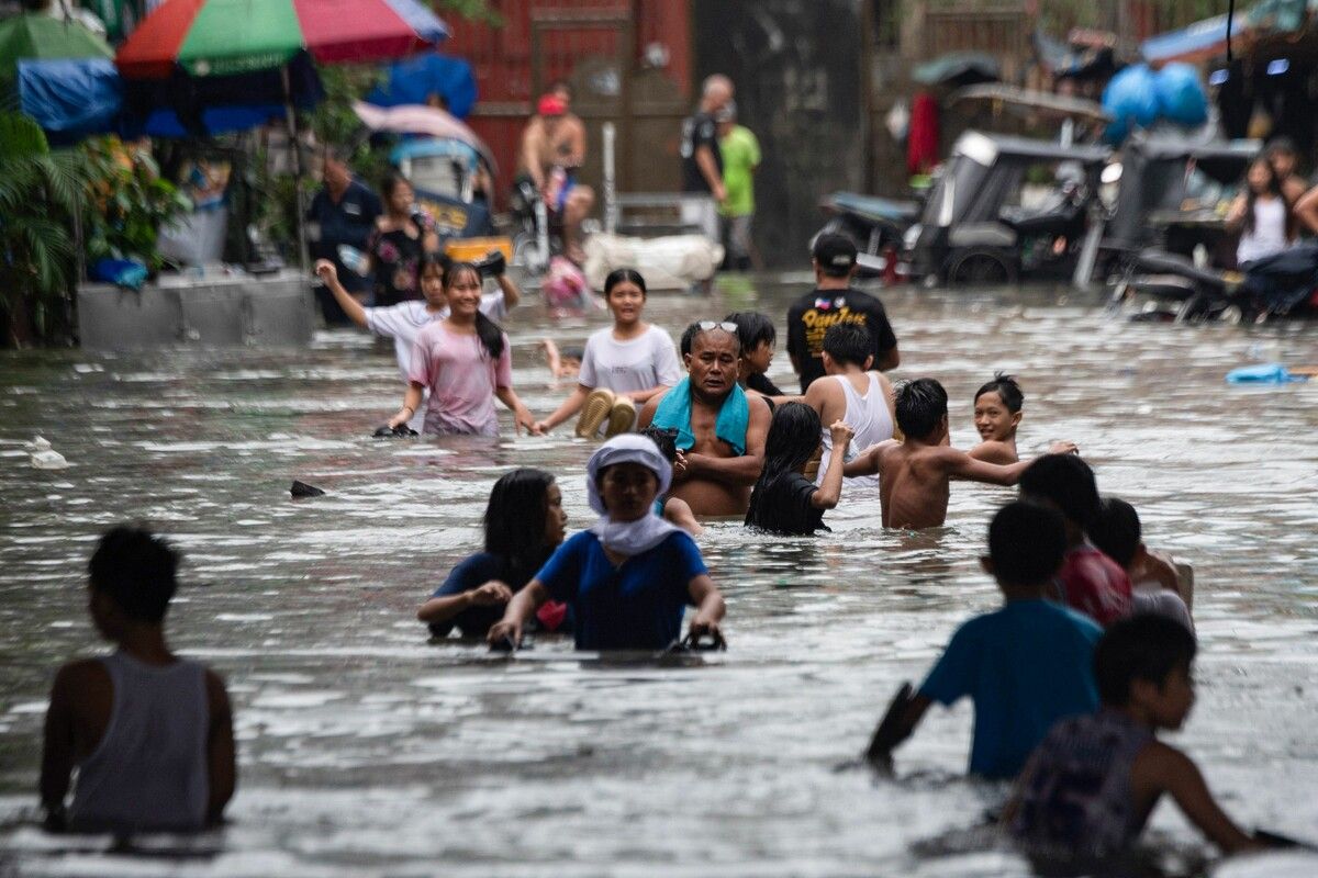 Viele mussten durch das trübe Wasser waten, um sich in Sicherheit zu bringen.⇒AFP