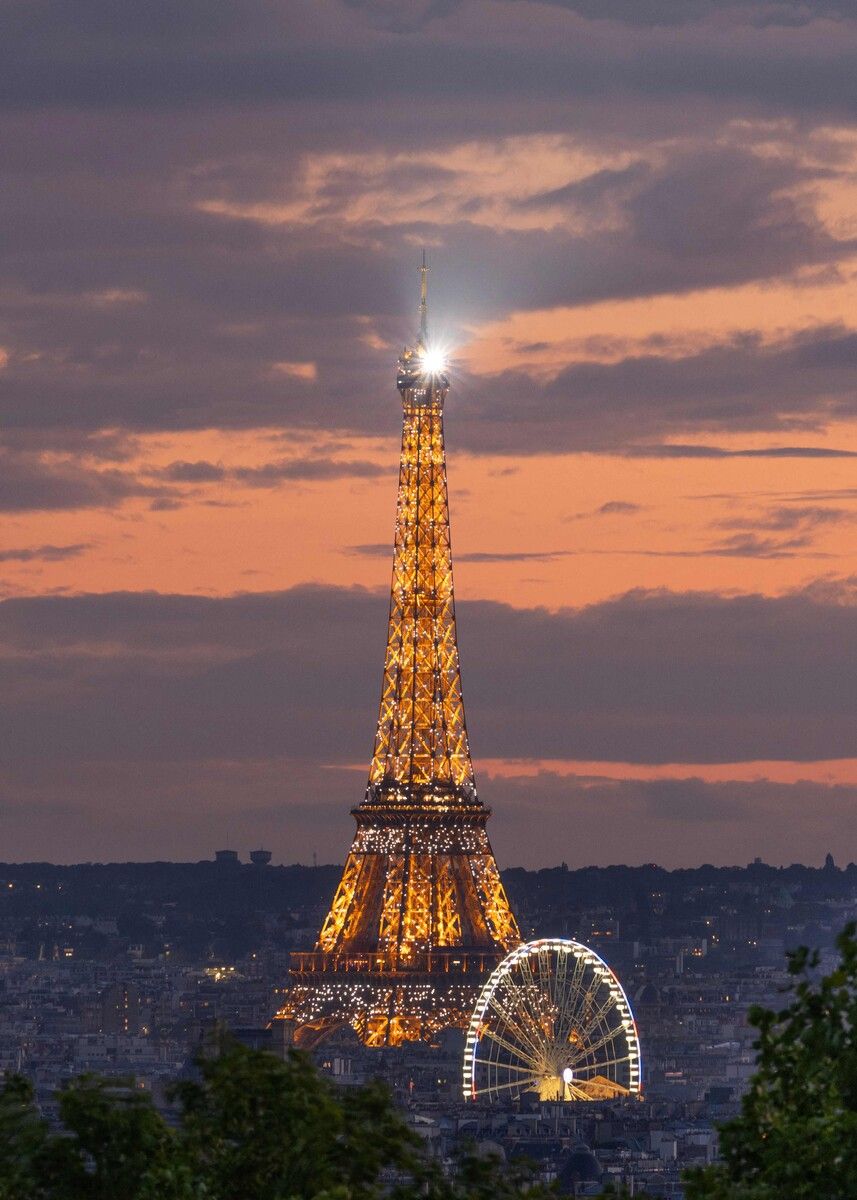 Der Eiffelturm in Paris leuchtet mit dem Sonnenuntergang um die Wette.