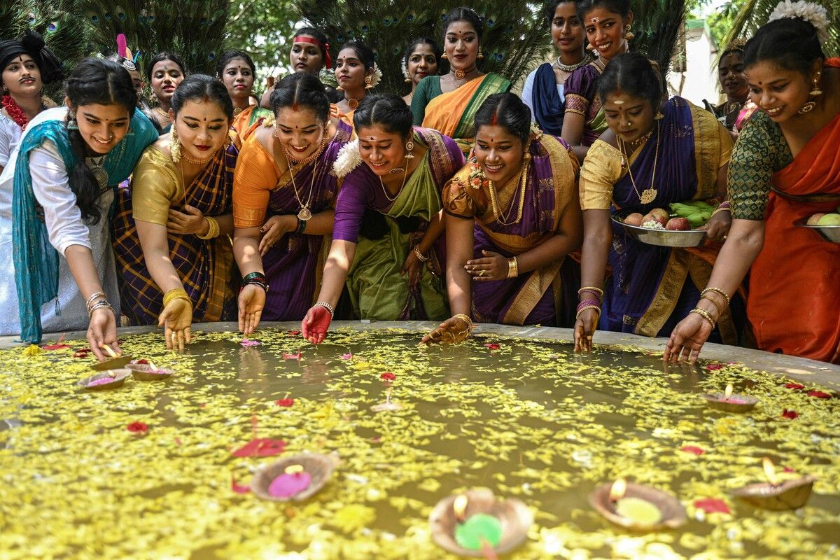 Indische Studenten lassen im Rahmen der Feierlichkeiten zum „Aadi Perukku”-Fest an einer Hochschule in Chennai Lampen mit Blumen in einem Wasserbecken schwimmen.