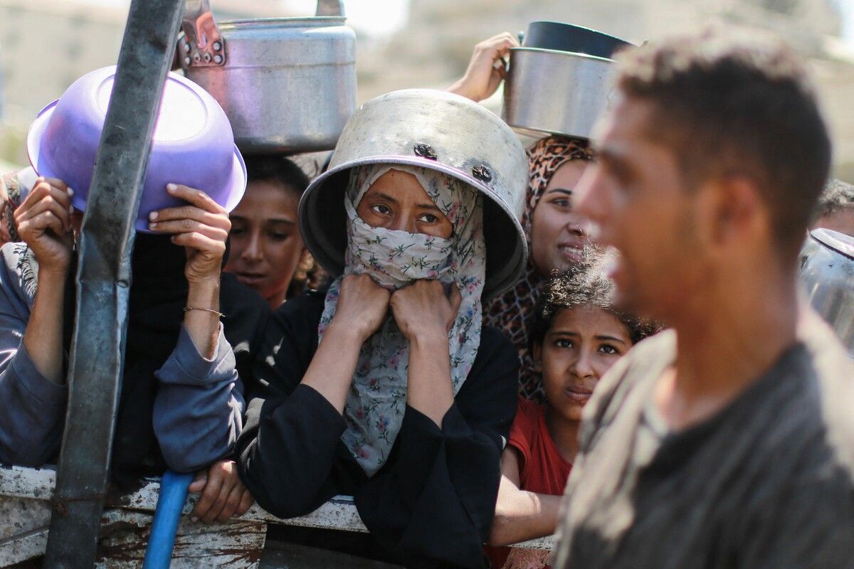 Menschen warten im Westen von Gaza-Stadt vor einer Suppenküche auf Essen.