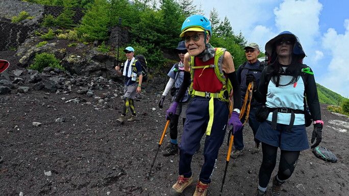 Mit Unterstützung seiner Begleiter schaffte es Akuzawa bis auf den Gipfel. ⇒GWR
