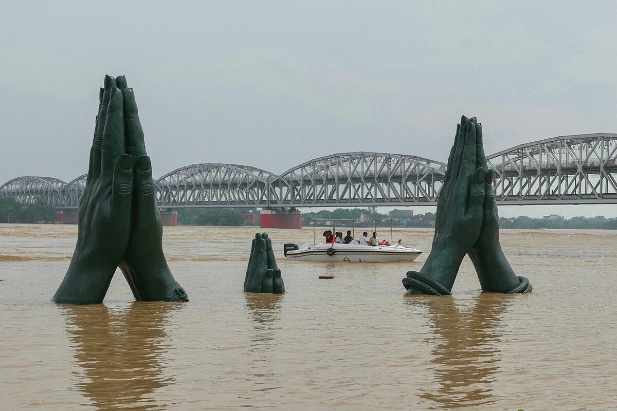 Skulpturen von betenden Händen ragen aus dem überfluteten Namo-Ghat in Varanasi, Indien, nachdem der Ganges durch starke Monsunregen stark angestiegen ist. AFP (5)