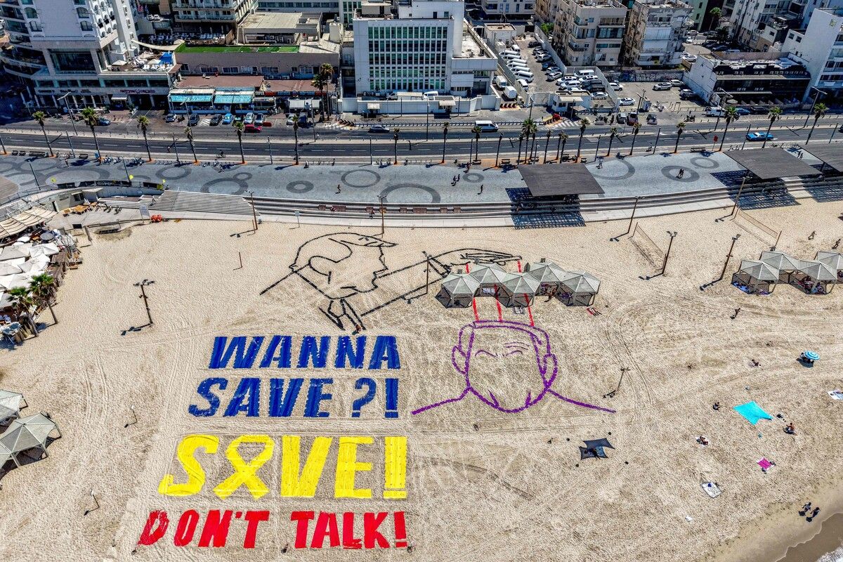 Diese Luftaufnahme zeigt eine Installation am Strand vor der US-Botschaft in Tel Aviv zum Gedenken an die israelischen Geiseln. Donald Trump und Benjamin Netanjahu mit Fäden verbunden. afp