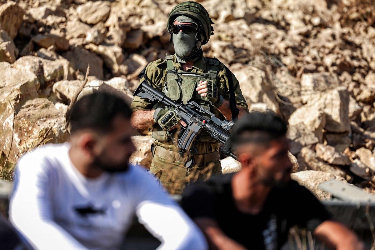 Ein israelischer Soldat steht Wache, während palästinensische Demonstrierende nahe Beit Ur al-Tahta gegen eine Siedlerstraße im Westjordanland protestieren. AFP (5)