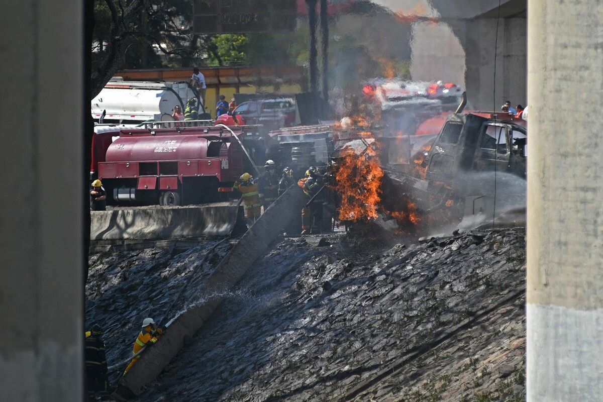 Feuerwehrleute löschen den Brand des explodierten Gastankwagens.⇒afp