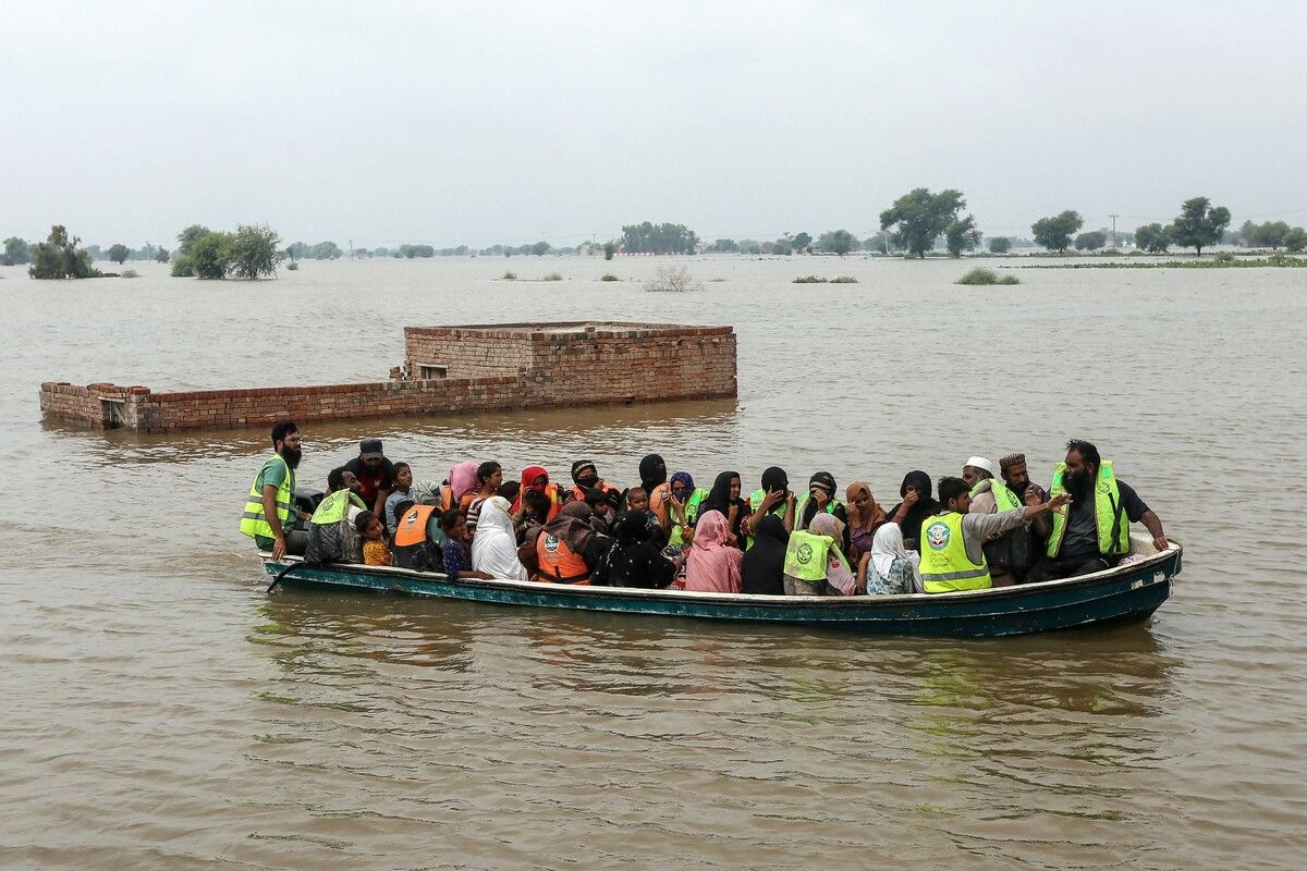 Pakistanische Helfer retten Dorfbewohner per Boot in Punjab, nachdem der Fluss Chenab wegen starker Monsunregen über die Ufer trat.