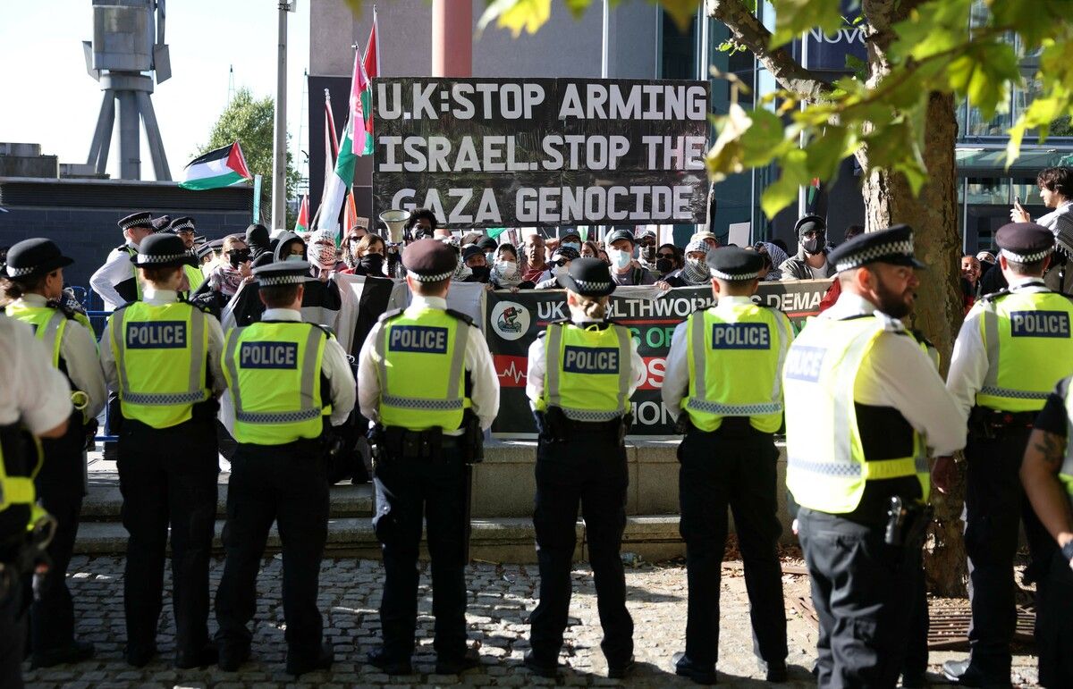 Polizisten stehen im Einsatz, während Demonstranten vor dem Eingang zur Waffenmesse „Defence and Security Equipment International“ im Osten Londons protestieren.