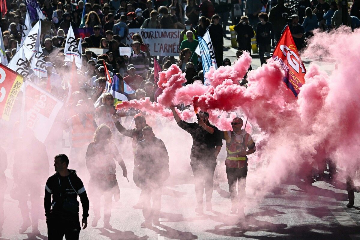 Demonstranten zünden rote Rauchfackeln bei einer Demonstration im westfranzösischen Nantes an. Die acht größten Gewerkschaften Frankreichs riefen zu Protest für „soziale Gerechtigkeit“ auf. AFP