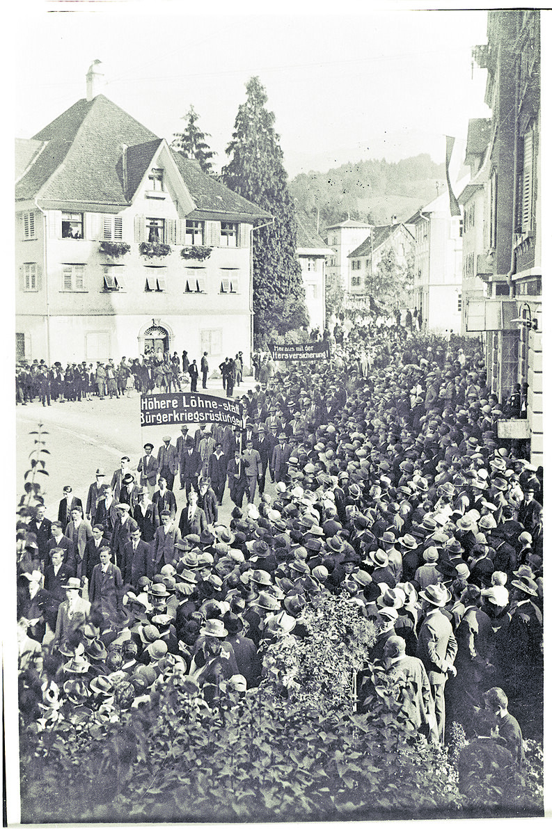 Demonstration mit klarer Botschaft: Für höhere Löhne und soziale Sicherheit gingen in Vorarlberg Hunderte Menschen auf die Straße – hier mit Transparenten gegen Bürgerkriegsrüstung und für die Altersversicherung.⇒Fotoarchiv der Johann-August-Malin-Gesellschaft, Vorarlberger Landesbibliothek
