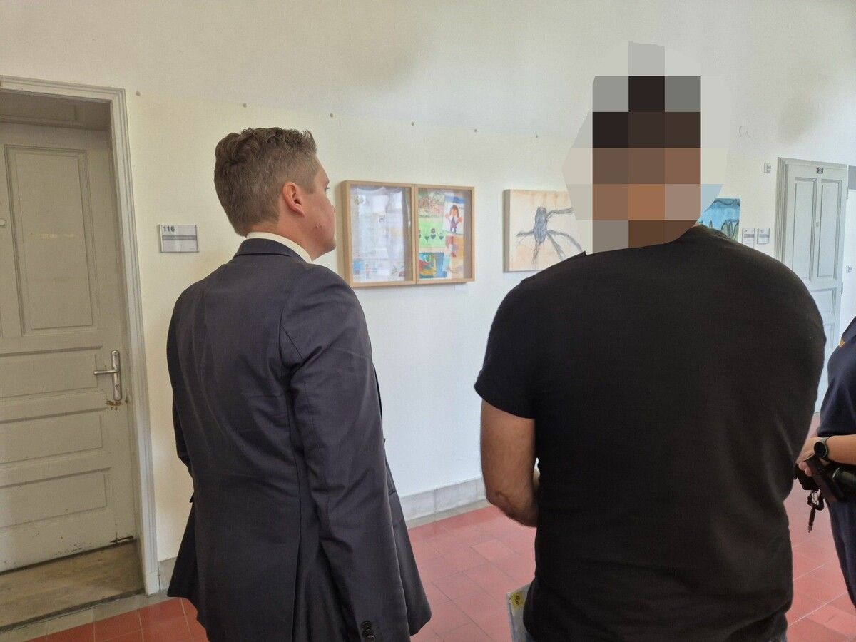 Der Angeklagte (r.) wartet vor dem Verhandlungssaal auf seinen Prozess. ⇒Eckert