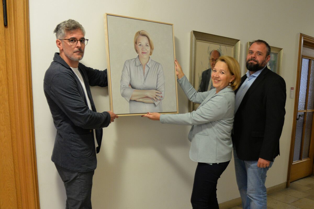 Drago Persic (v.l.), Andrea Kaufmann und Bürgermeister Markus Fäßler hängen das Bild im Rathaus auf.⇒stadt Dornbirn (2)