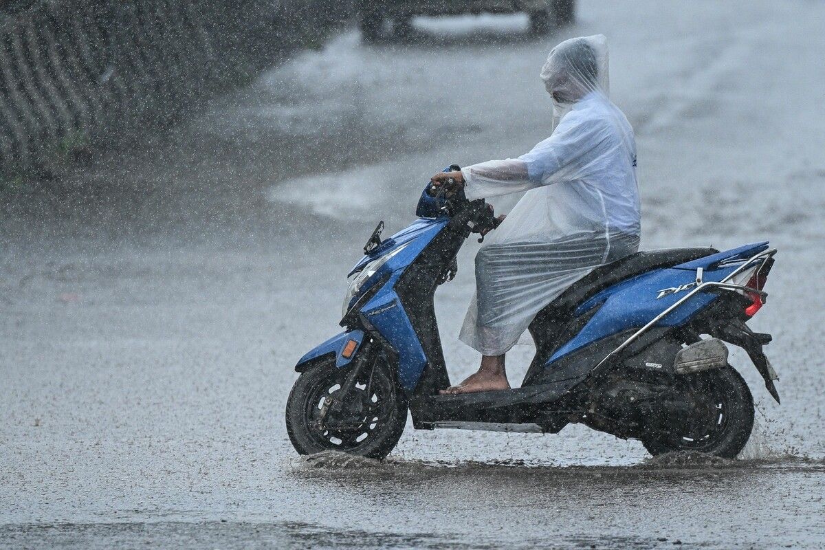 Ein Mopedfahrer schützt sich in Chennai mit Komplett-Plastikregenkleidung vor starkem Regen nach einer Zyklonwarnung.