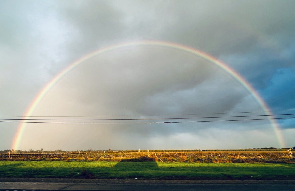 Ein Regenbogen überspannt die Landschaft entlang des Highway 99 in Zentral-Kalifornien.
