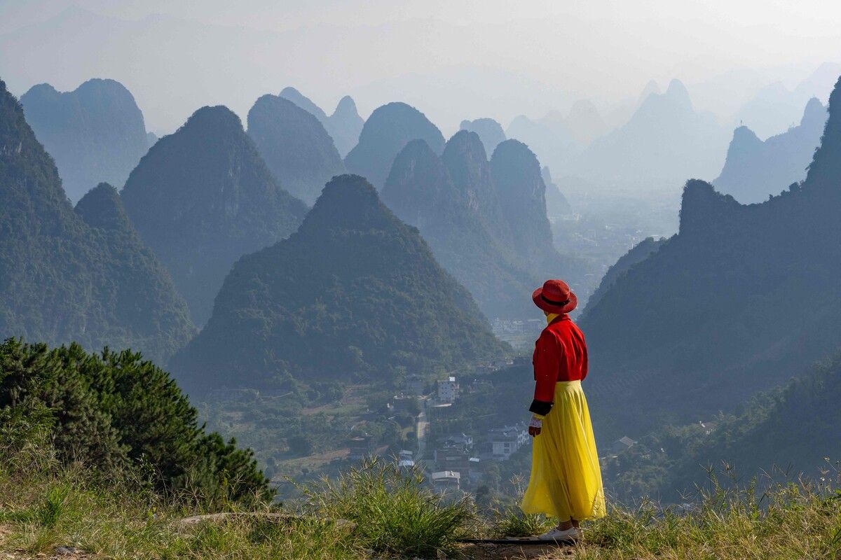 Eine Frau blickt auf die Karstberge bei Yangshuo in Guangxi, China. Die Karstlandschaften in Südchina zählen seit 2007 zum UNESCO-Weltnaturerbe. AFP (5)