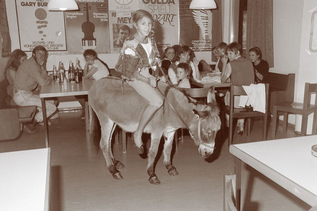 „Mädchen reitet Esel in einer Kantine“ von 1983 (zwei Fotografien) darf definitiv als einer der Höhepunkte in Spangs Tierfotografie betrachtet werden.⇒Oskar Spang, Stadtarchiv Bregenz