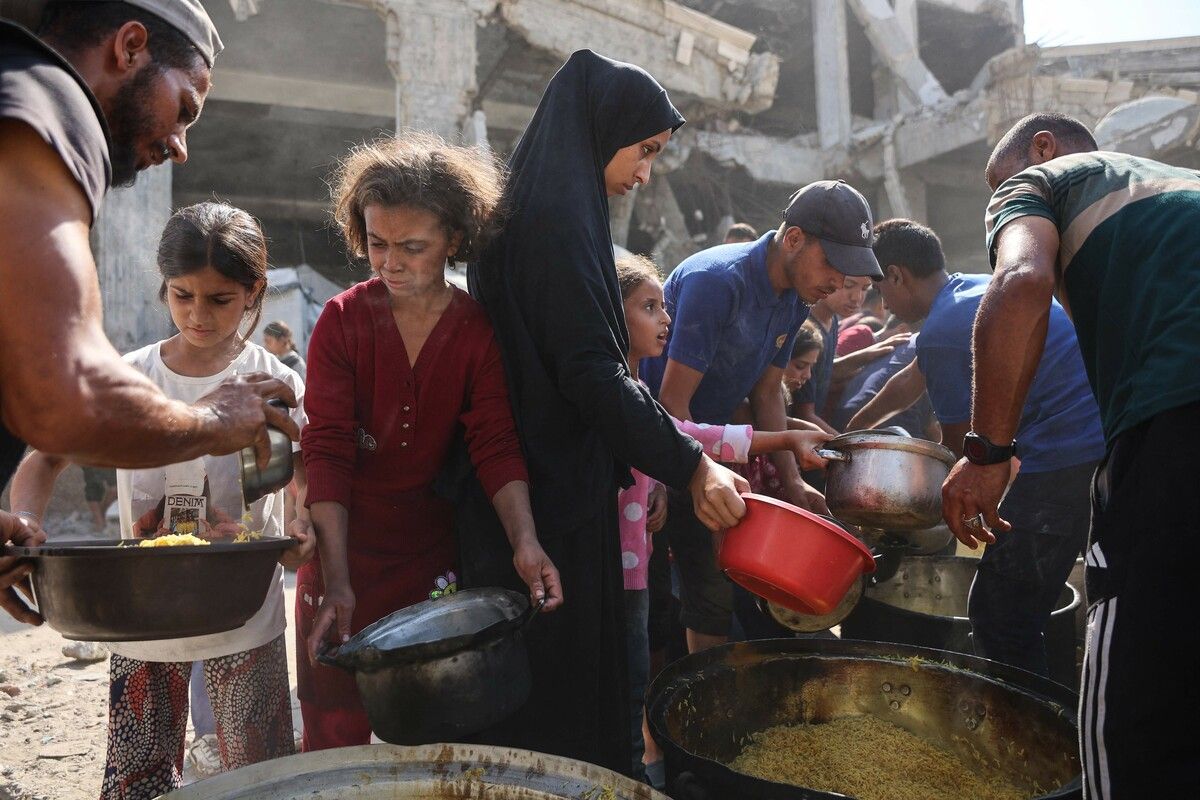 Palästinensische Familien stehen vor der beschädigten Imam-al-Shafi'i-Moschee in Gaza für Lebensmittelrationen an. AFP (5)