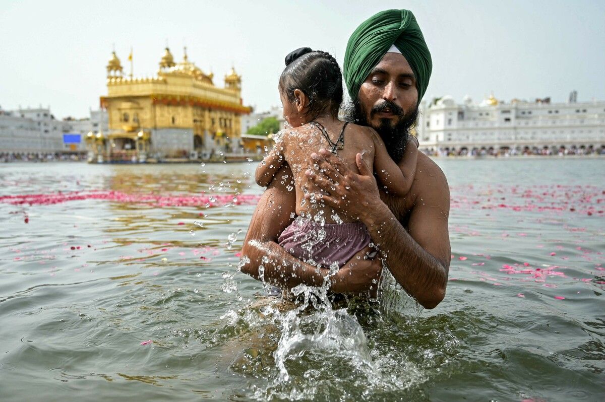 Rituelles Bad im heiligen Sarovar am Goldenen Tempel in Amritsar in Indien.