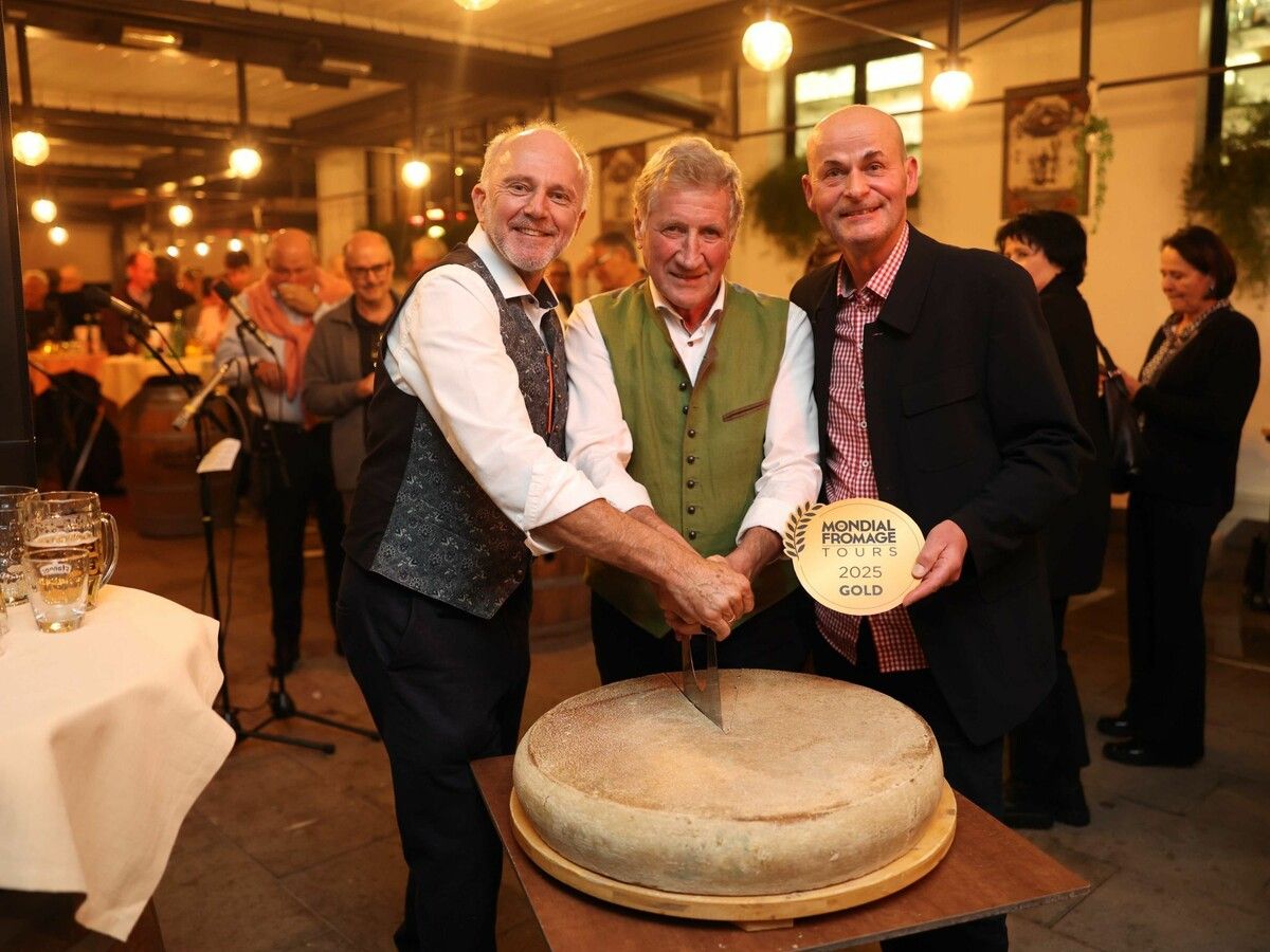 Die LR a. D. Sepp Eisl (v.l.) und Erich Schwärzler mit dem Jubilar beim Anschnitt des Siegerkäses.⇒Arno Meusburger