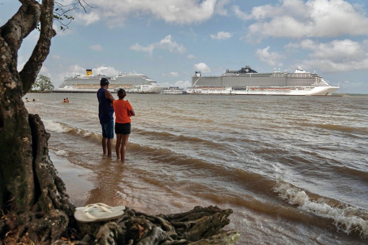 Menschen am Strand des Guam Flusses in Belém in Brasilien beobachten Kreuzfahrtschiffe, die im Hafen vor Anker liegen.