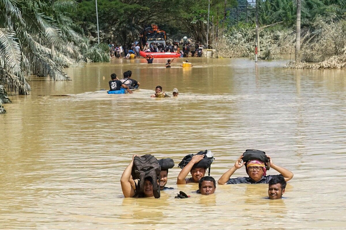 Bewohner waten im nord-sumatrischen Kuala Simpang durch das mannshohe Hochwasser. AFP (5)