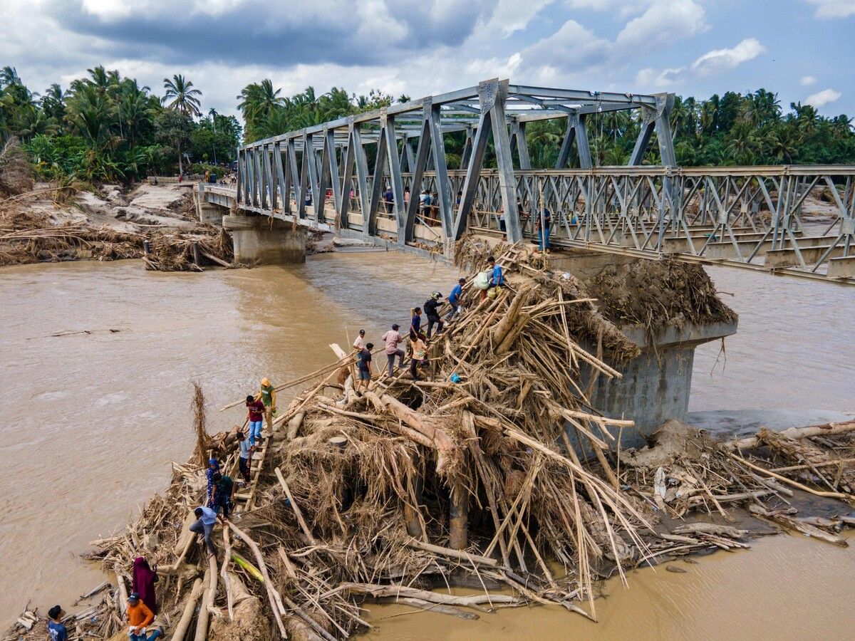 Ein Luftbild zeigt Einwohner in Indonesien, die über Trümmer klettern, um den Fluss auf einer neu gebauten Brücke zu überqueren, die Aceh und die Provinz Nord-Sumatra verbindet.