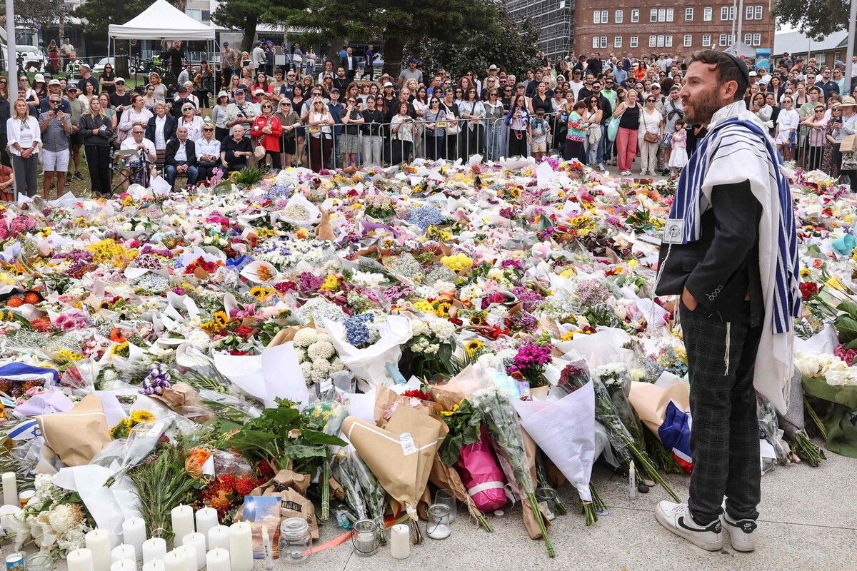 Ein Rabbi spricht vor dem Bondi Pavilion in Sydney im Rahmen einer Trauerfeier nach dem Anschlag zu den Trauernden. AFP (5)